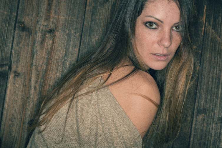 Young woman with brown long straight hair indoor fashion portrai